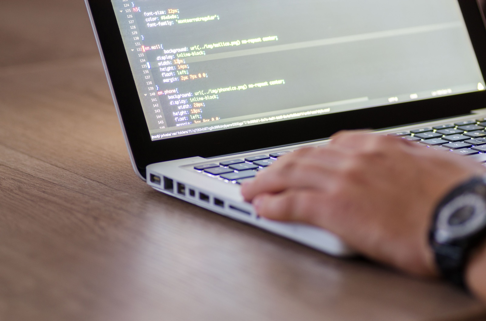 Programador desarrollando software empresarial en un ordenador portátil